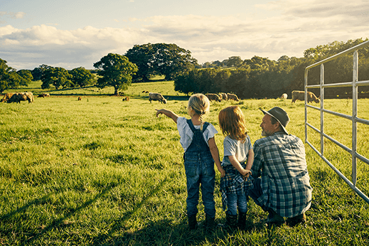 Rearview shot of a male farmer and his two young kids on their farm.